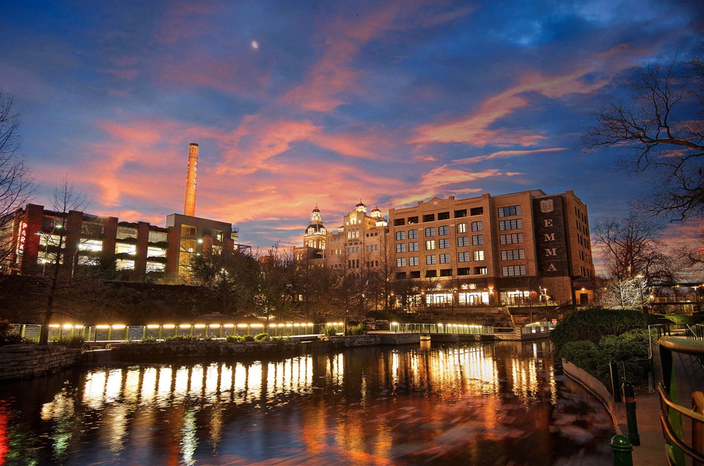a city at night with a river and buildings