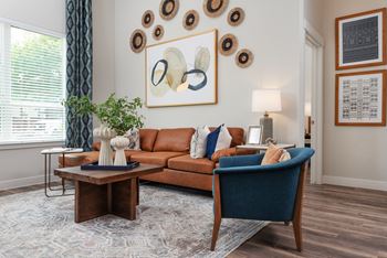 a living room with a brown couch and blue chairs