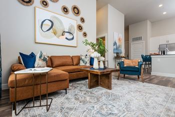 a living room with a brown couch and blue chairs