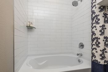 a white bathtub in a bathroom with a black and white shower curtain