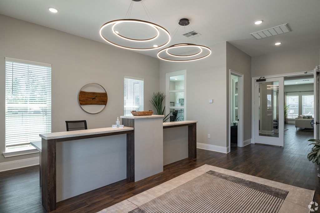 an office lobby with a reception desk and a mirror at Beau Chene Lake Charles Apartments in Lake Charles, LA 70605