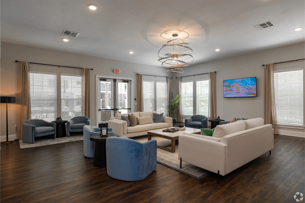 clubhouse with couches and chairs and a table at Beau Chene Lake Charles Apartments in Lake Charles, LA 70605
