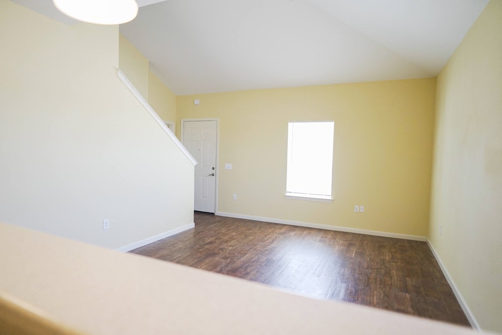 an empty living room with yellow walls and a window