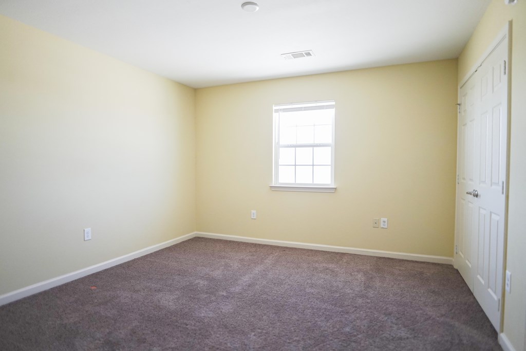 a room with carpet and a window and a door