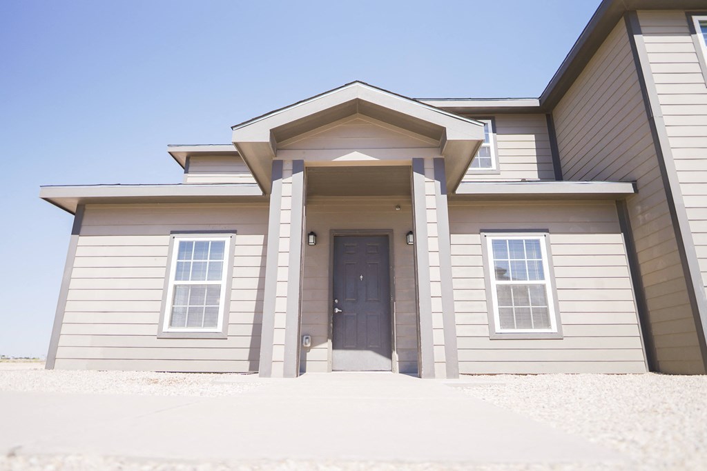 the front of a house with a blue sky in the background
