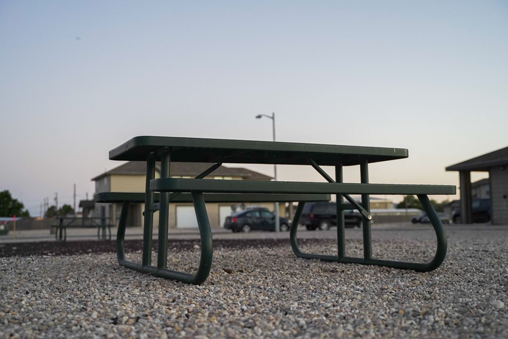 a green picnic table in a parking lot