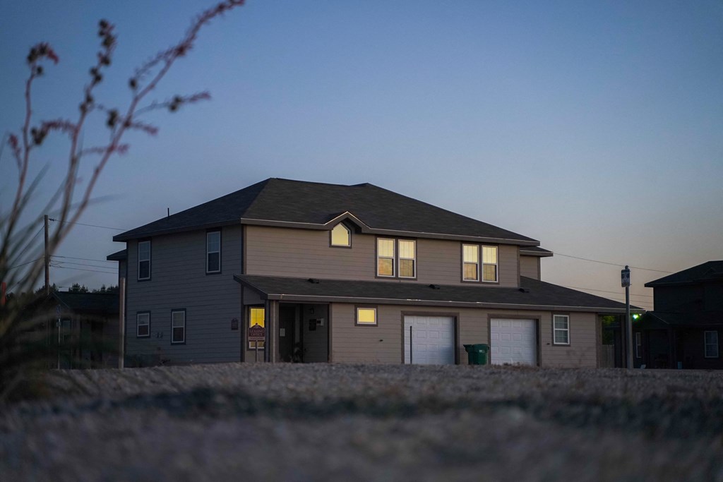a house at dusk with the lights on in the windows