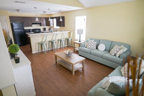 a living room and kitchen with a couch and a table