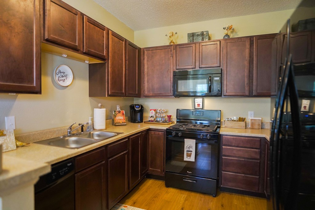 a kitchen with black appliances and wooden cabinets