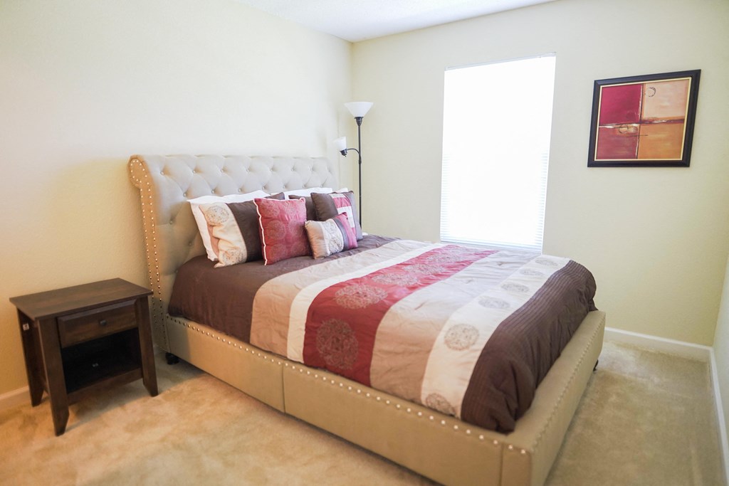 a bedroom with a bed with a quilt and pillows on it