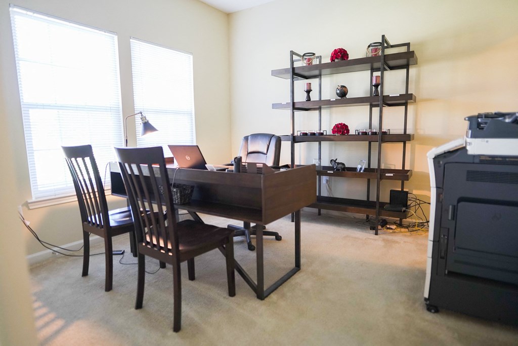 a dining room with a table and chairs and a desk with a laptop