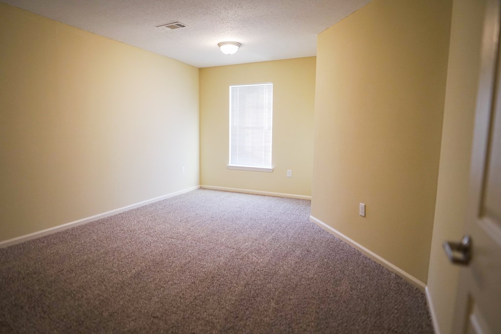 a room with a carpeted floor and a window