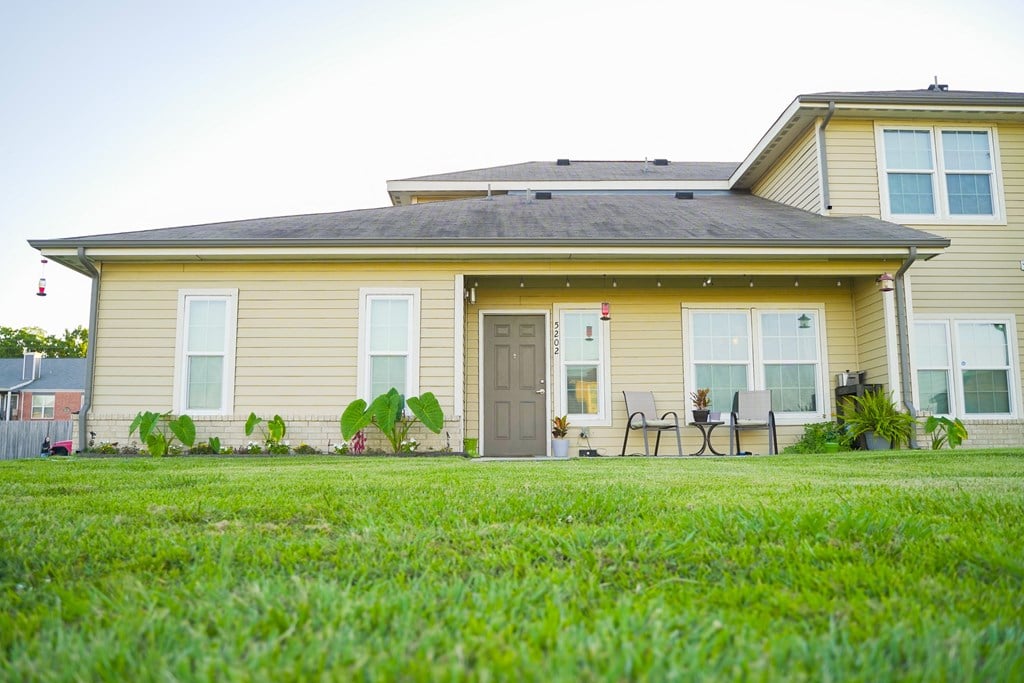 a yellow house with a lawn in front of it