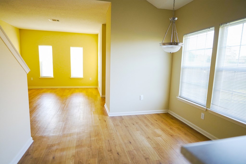 an empty living room with yellow walls and wood floors