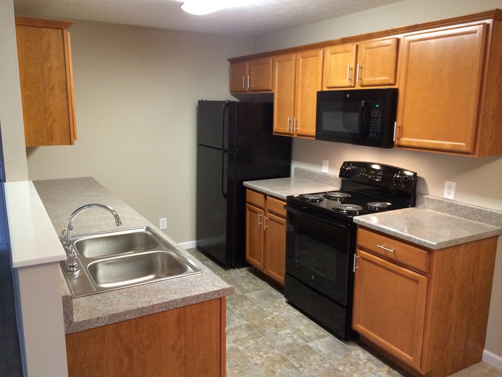 a kitchen with black appliances and wooden cabinets