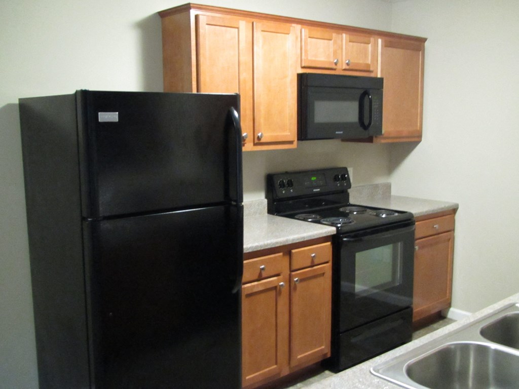a kitchen with black appliances and wooden cabinets