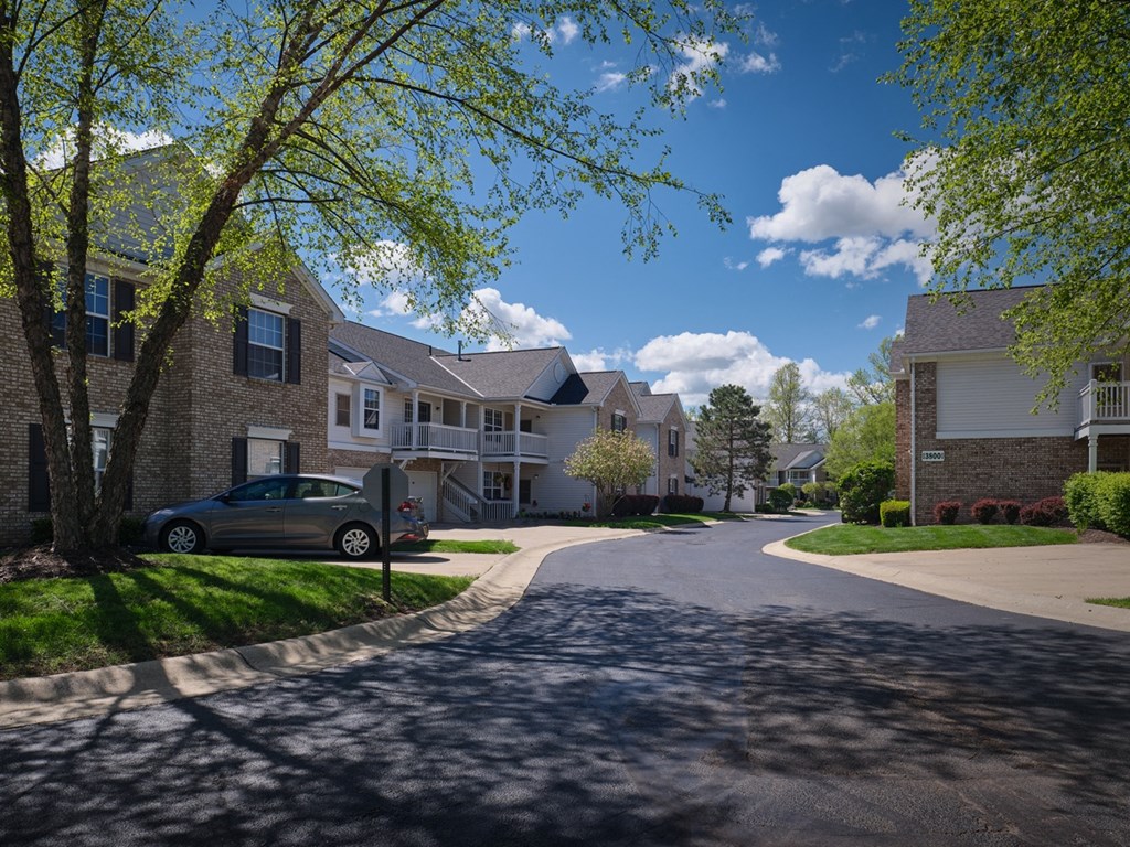 a row of houses on a street with a car driving down the street