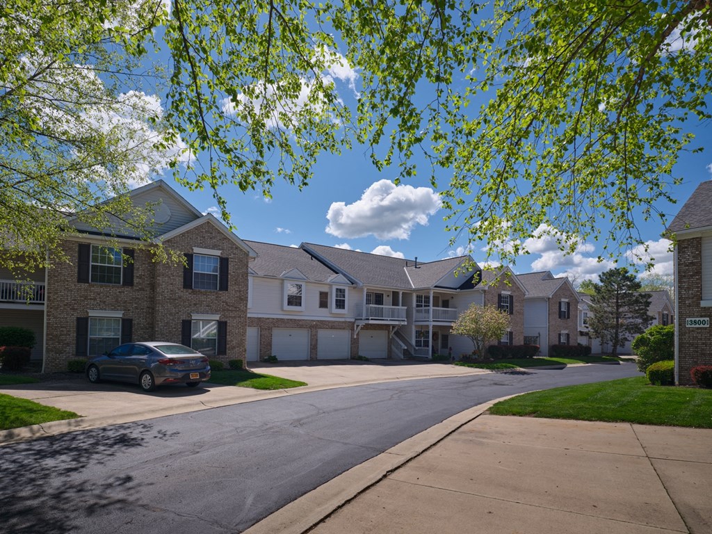 a street view of an apartment complex with a car parked in front