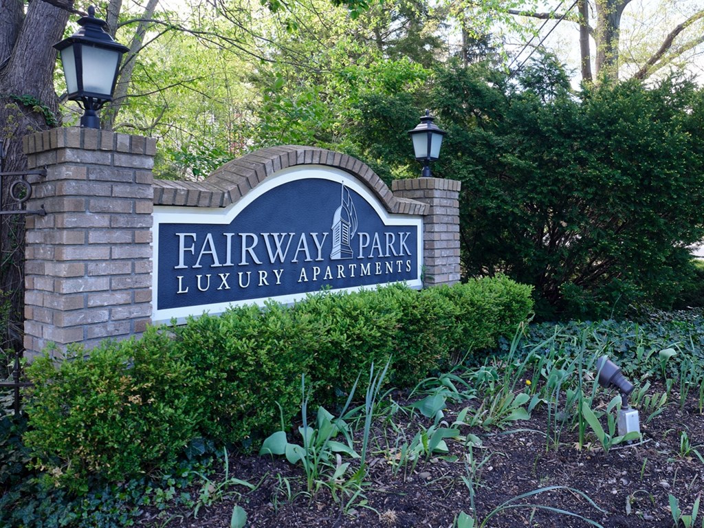 a sign for fairway park luxury apartments on a brick wall