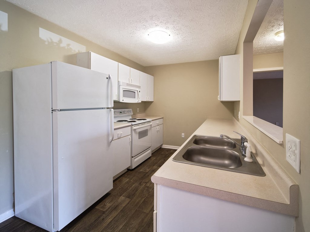 a kitchen with white appliances and a sink and a refrigerator