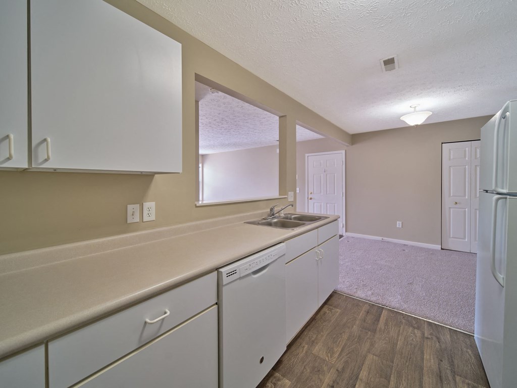 a kitchen with white cabinets and a sink and a refrigerator