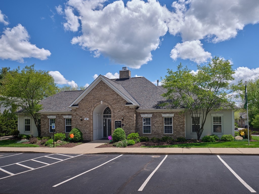 a brick house with an arched door and a parking lot