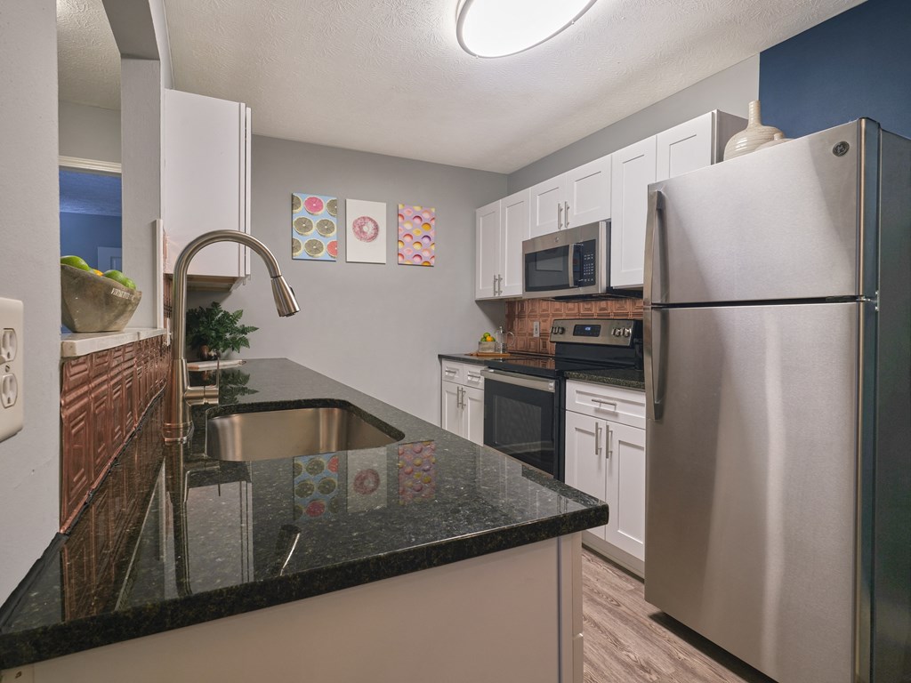 an updated kitchen with stainless steel appliances and granite counter tops
