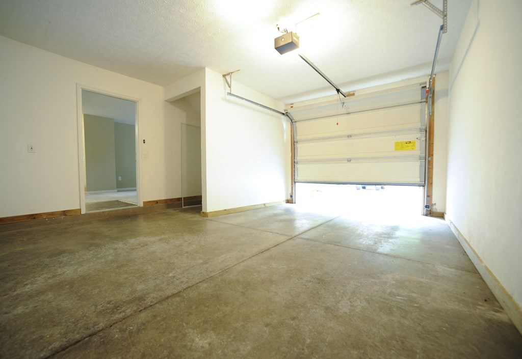 a empty room with a garage door and a light on the ceiling