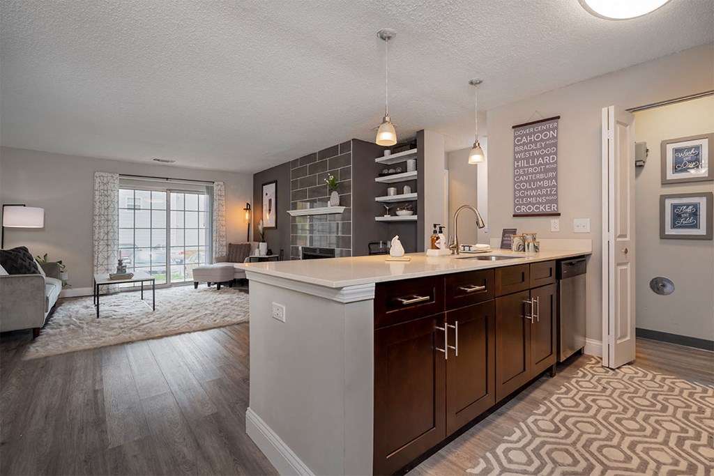 an open kitchen and living room with a large counter top