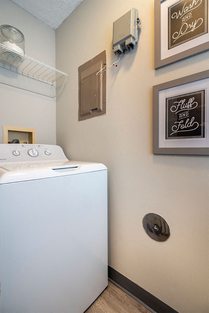 a washer and dryer in a laundry room with pictures on the wall