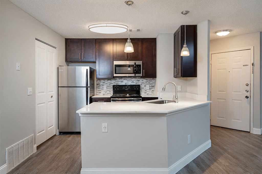 a kitchen with a large island and a stainless steel refrigerator