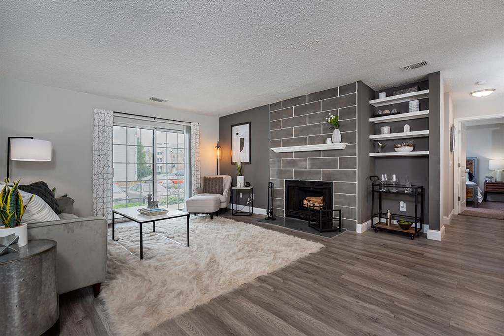 a living room with a brick fireplace and a white rug