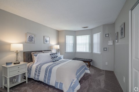 the master bedroom has a large bed and windows