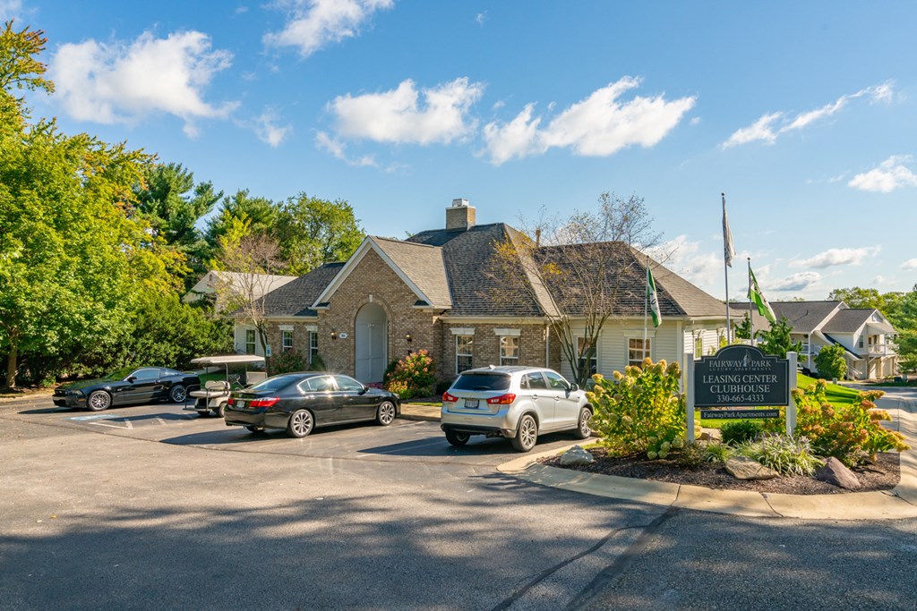 a parking lot with cars in front of a house