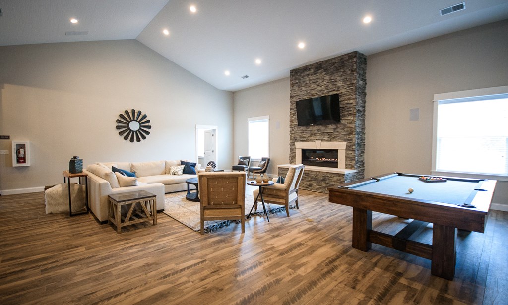 an open living room with a pool table and a large window