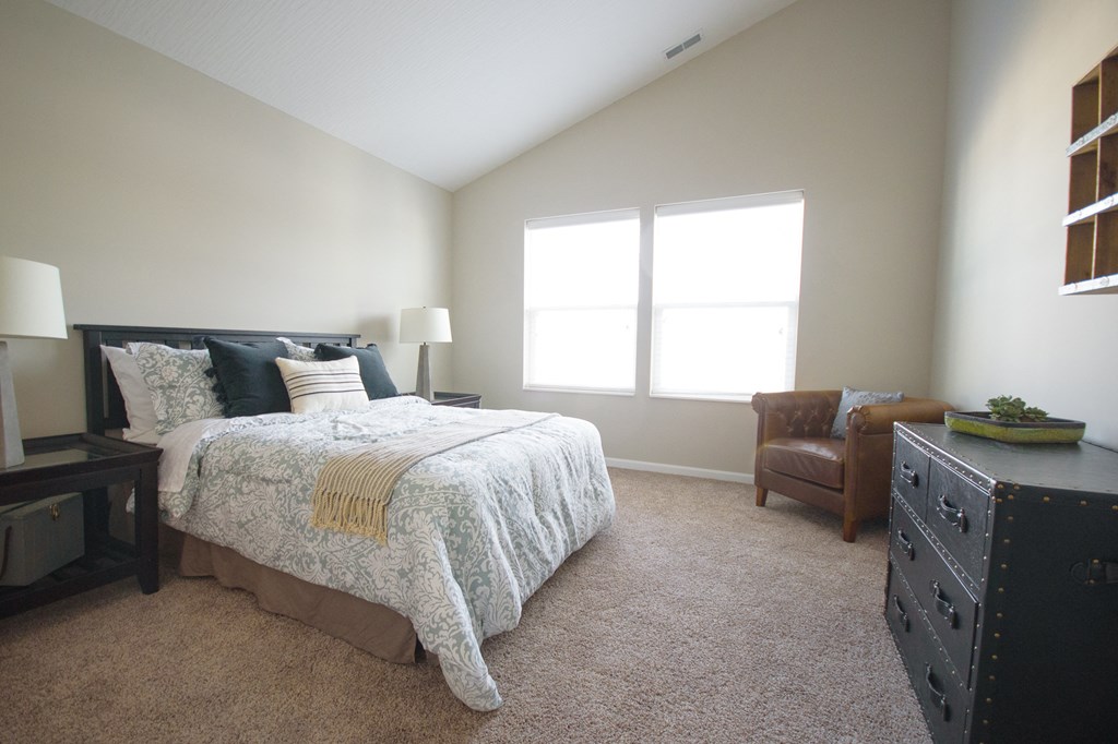 a bedroom with a bed and a dresser and a window