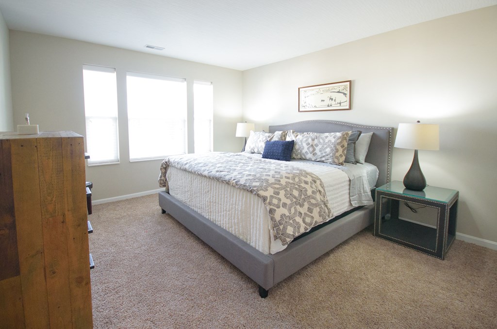 a bedroom with a bed and two windows