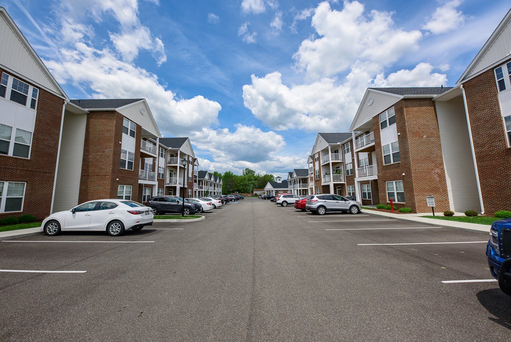 an empty parking lot with apartment buildings on both sides of it