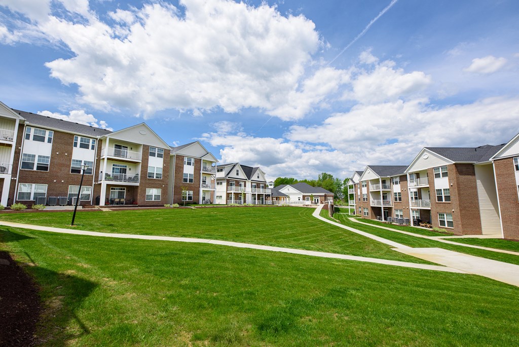 an exterior view of an apartment building on a green lawn