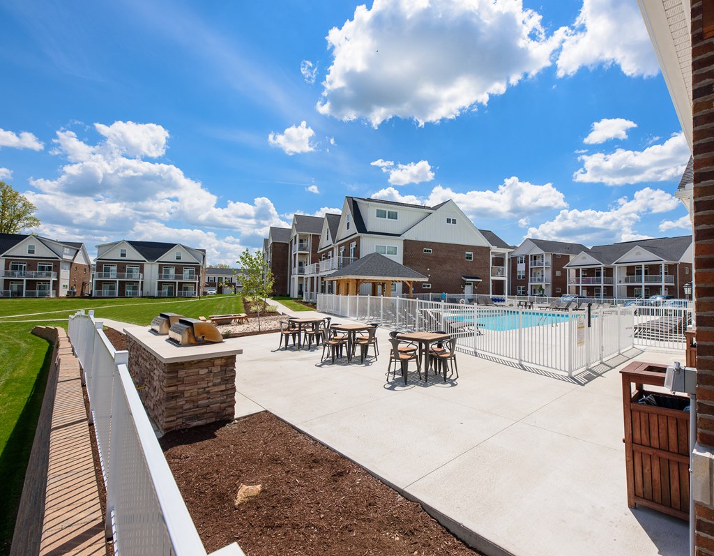 our apartments have an outdoor pool with tables and chairs