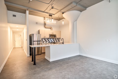 A kitchen area with a checkered table and a refrigerator.