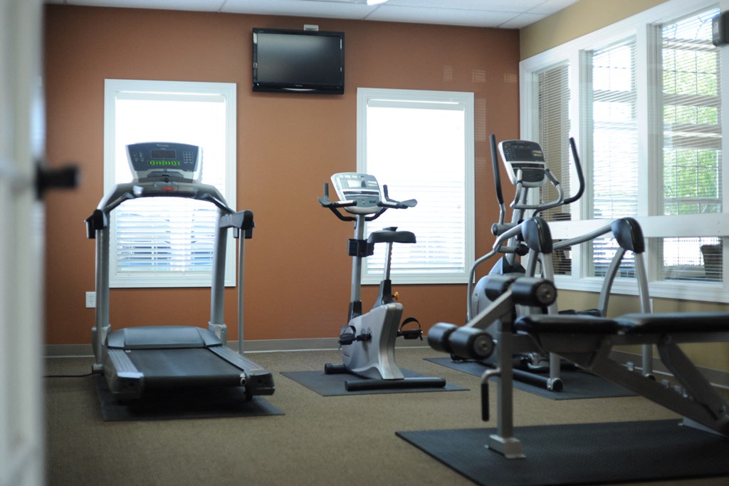 a gym with exercise equipment and a tv