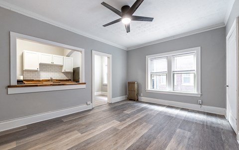 an empty living room with a ceiling fan and a window