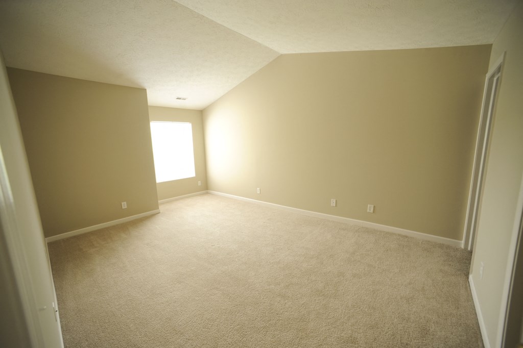 an empty room with carpet and a window