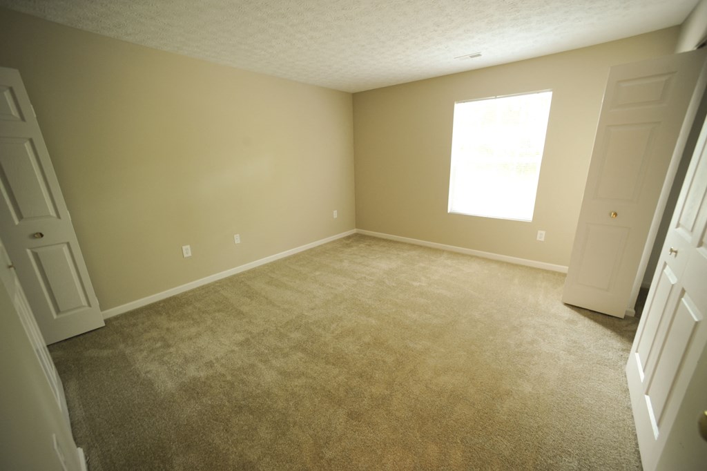 an empty room with carpet and a window