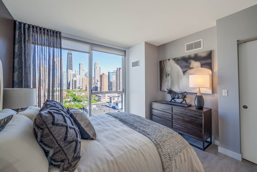 1 bedroom with queen sized bed, dresser, and night stand with lamp