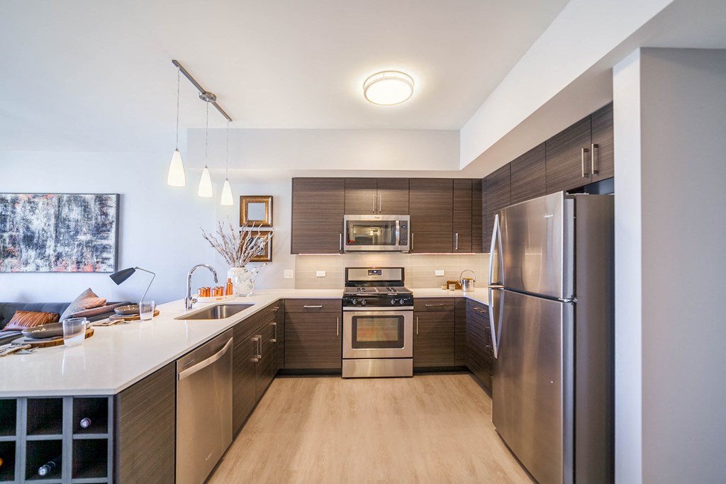 One bedroom kitchen with built-in wine rack, stainless steel appliances, cherry cabinets and hardwood flooring