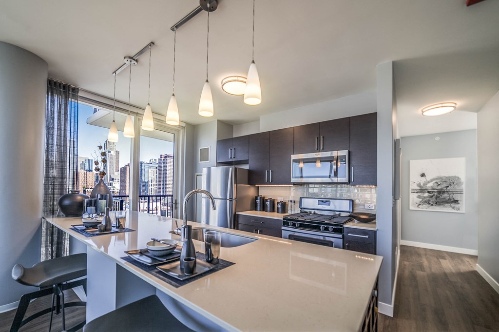 One bedroom kitchen with built-in wine rack, stainless steel appliances, cherry cabinets and hardwood flooring