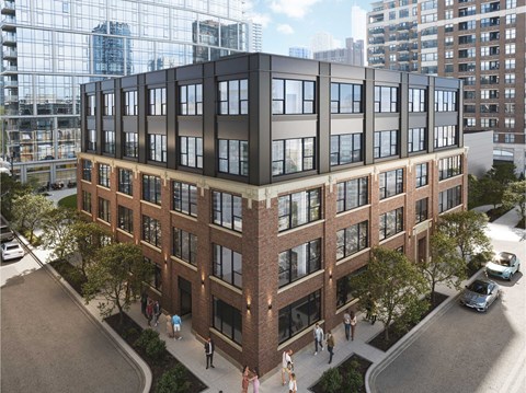 A modern multi-story building with a glass facade on the top floor and brick facade on the bottom floor.