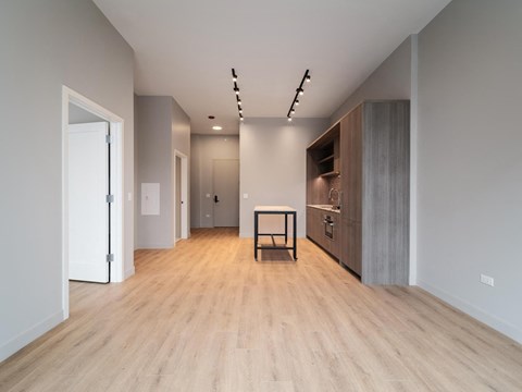 A modern kitchen with a wooden floor and a table with chairs.